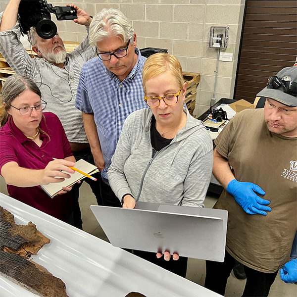 Jim works with a team to begin the examination of the canoe.